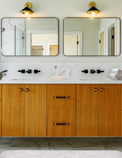 Modern bathroom with dual sinks, wooden vanity, and rectangular mirrors.